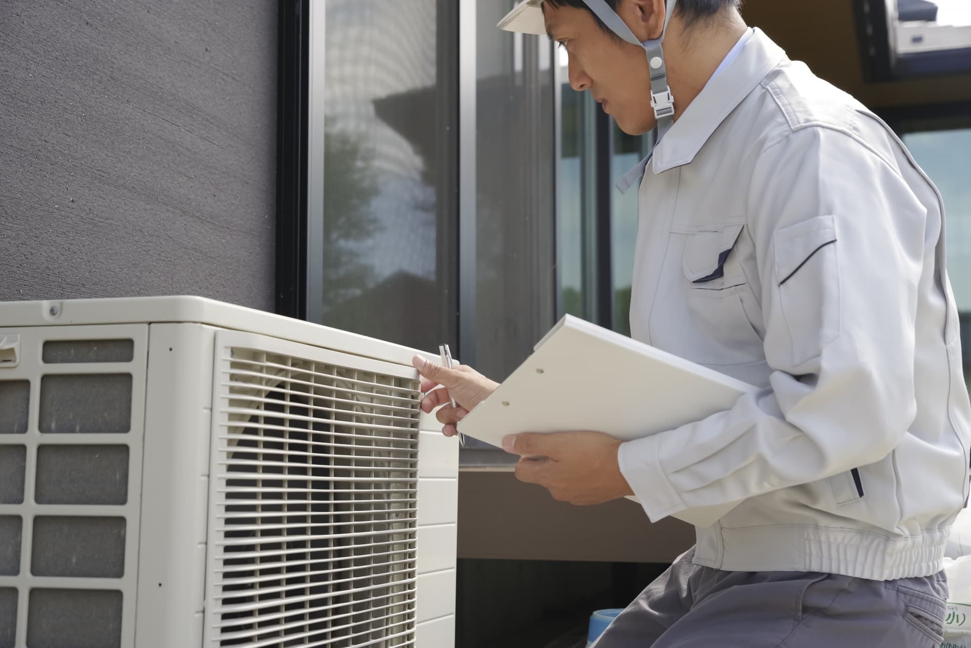 エアコンの室外機を点検する男性