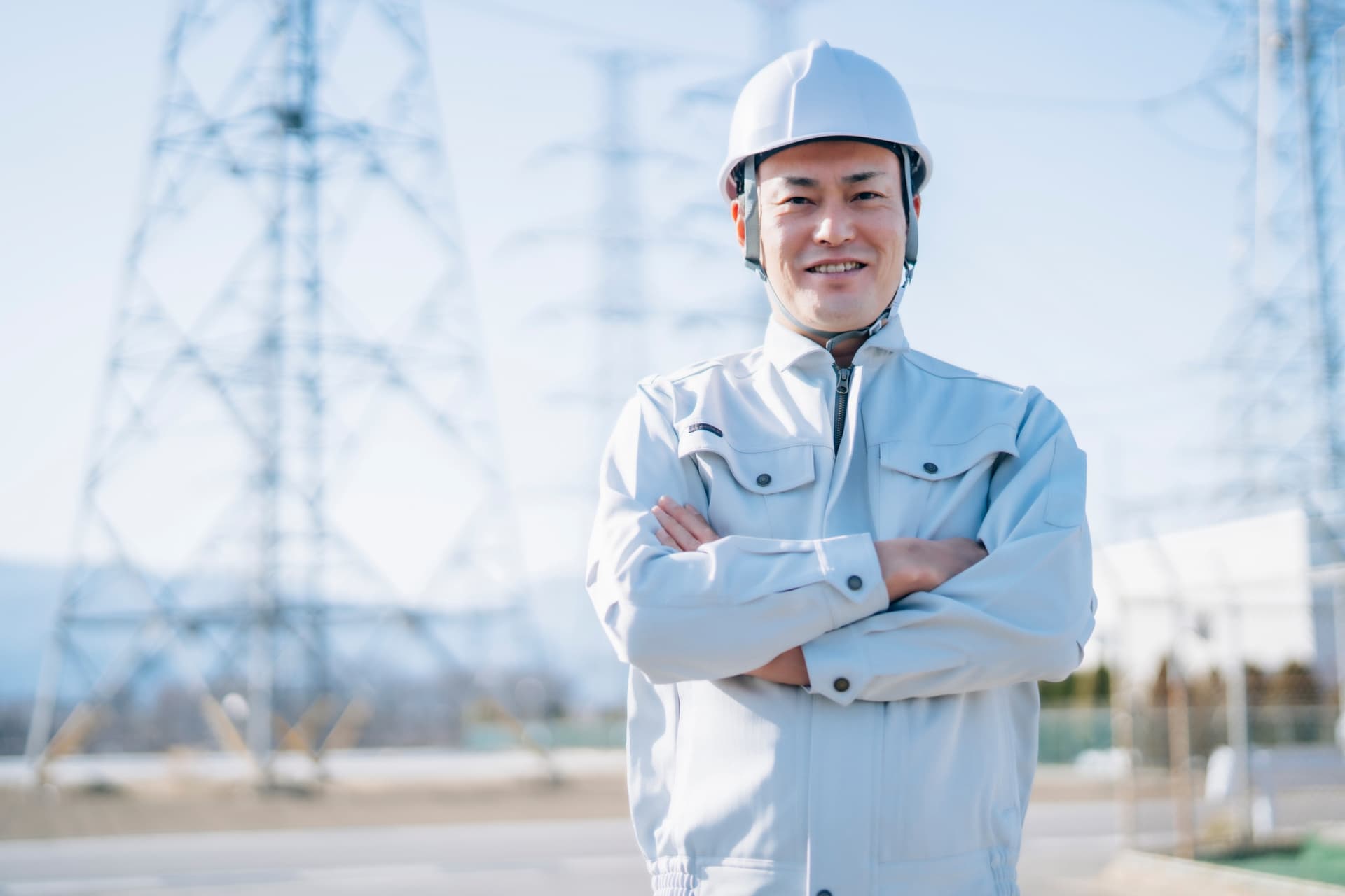 ヘルメットをかぶって腕組みをしている電気工事の作業員